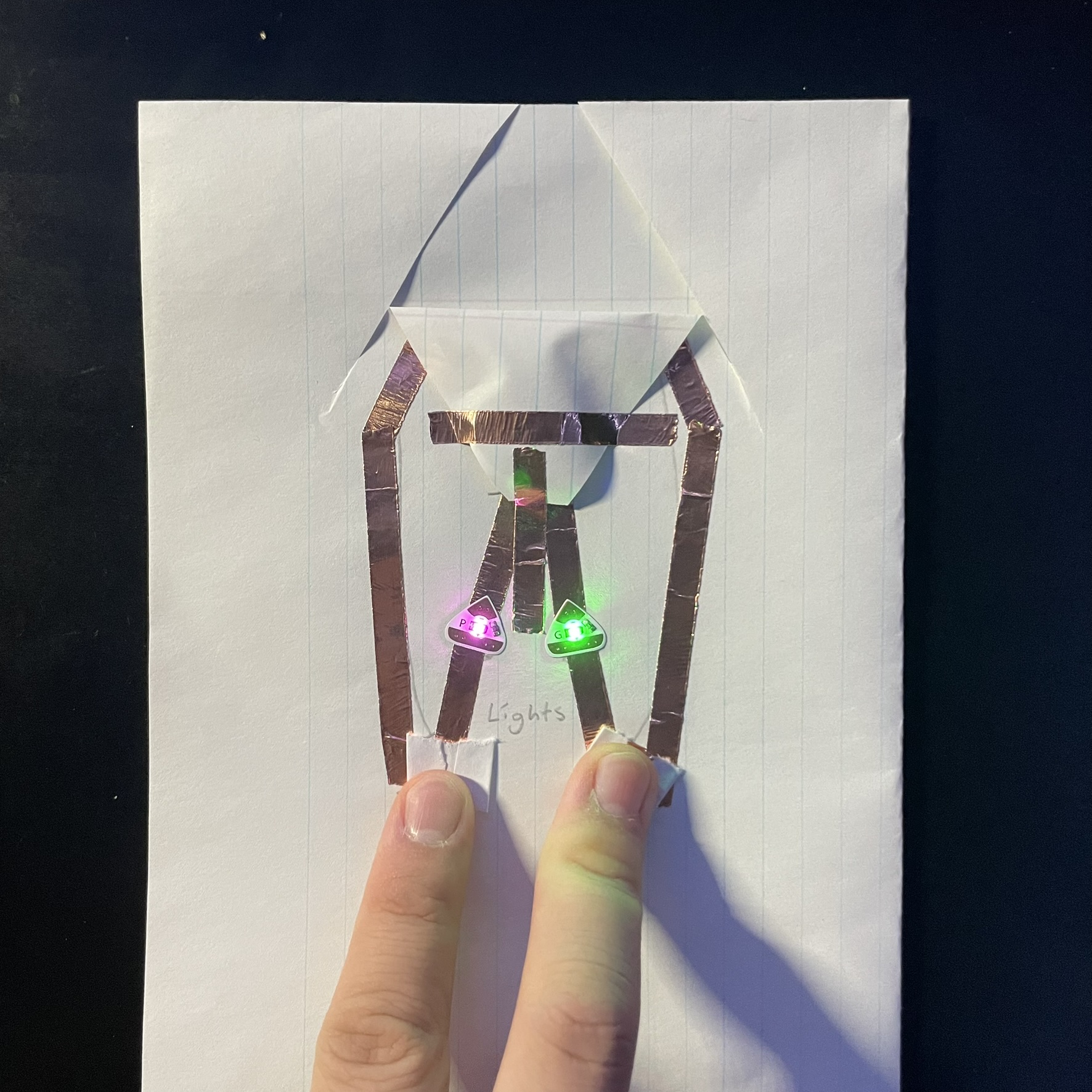 This is the circuit being activated, the top part of the circuits touches the top of the battery and the lights are activated by two switches one for each, they both work separately